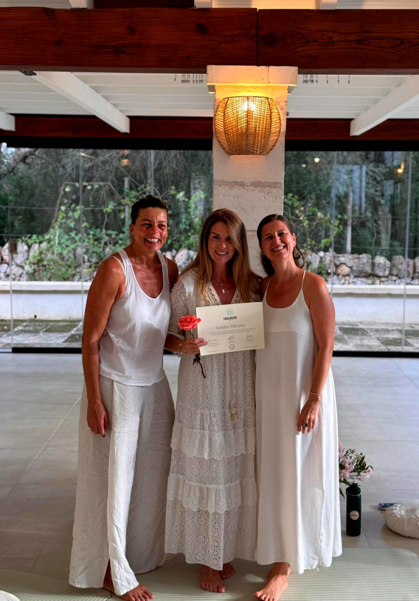 Sandra holding her training certificate alongside two women